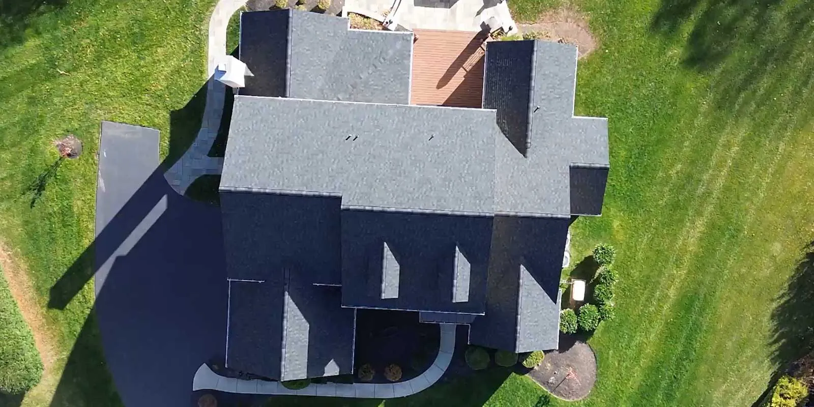 Aerial view of a completed dark asphalt-shingle roof
