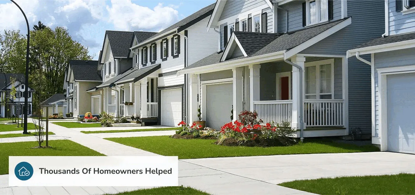A street of homes with new siding and roofs; the photo carries Hero’s own caption “Thousands Of Homeowners Helped”