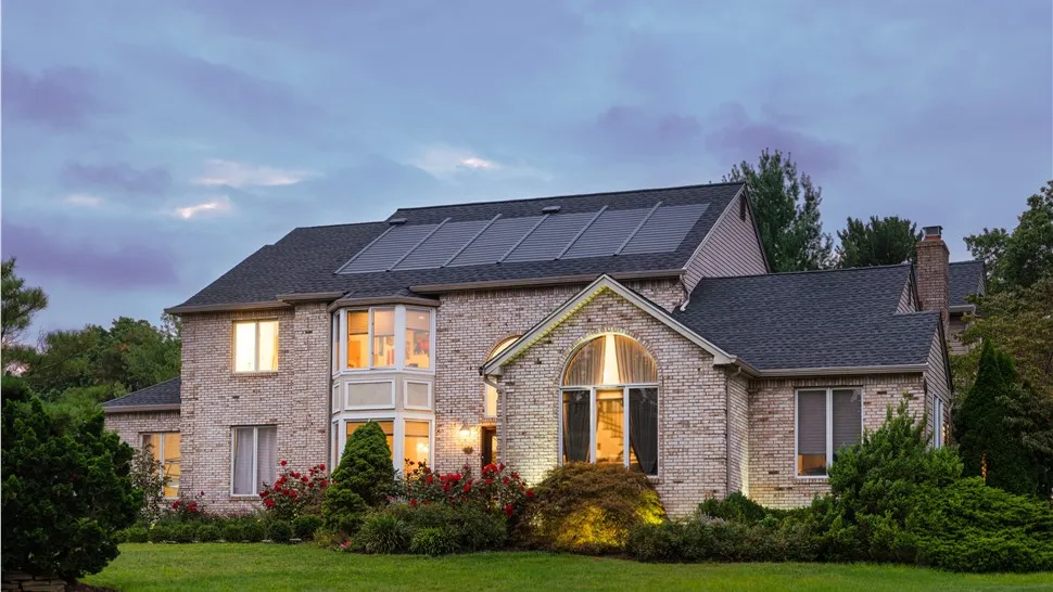 Home with a rooftop solar array at dusk