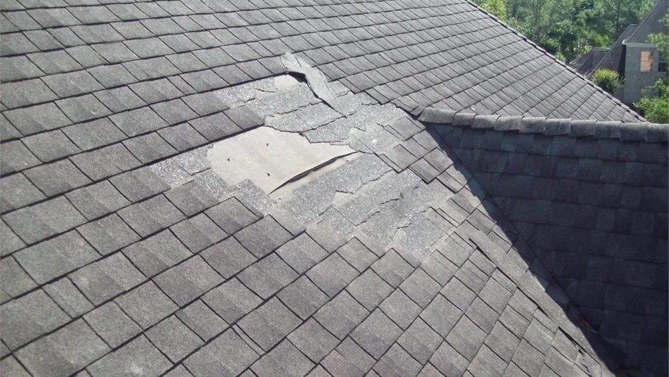 Close view of a roof slope with a section of missing shingles
