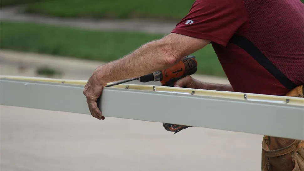 Installer fastening a section of K-style gutter