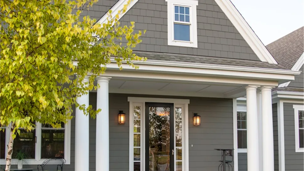 Covered porch entry on a home with gray shingle-style siding