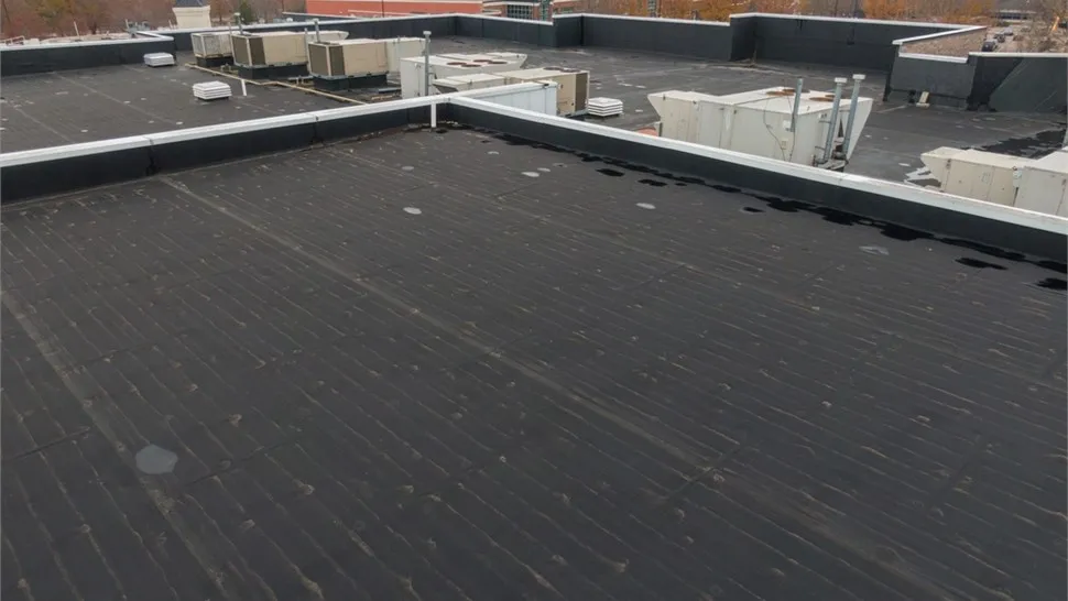 Low-slope commercial membrane roof with parapet walls and rooftop HVAC units