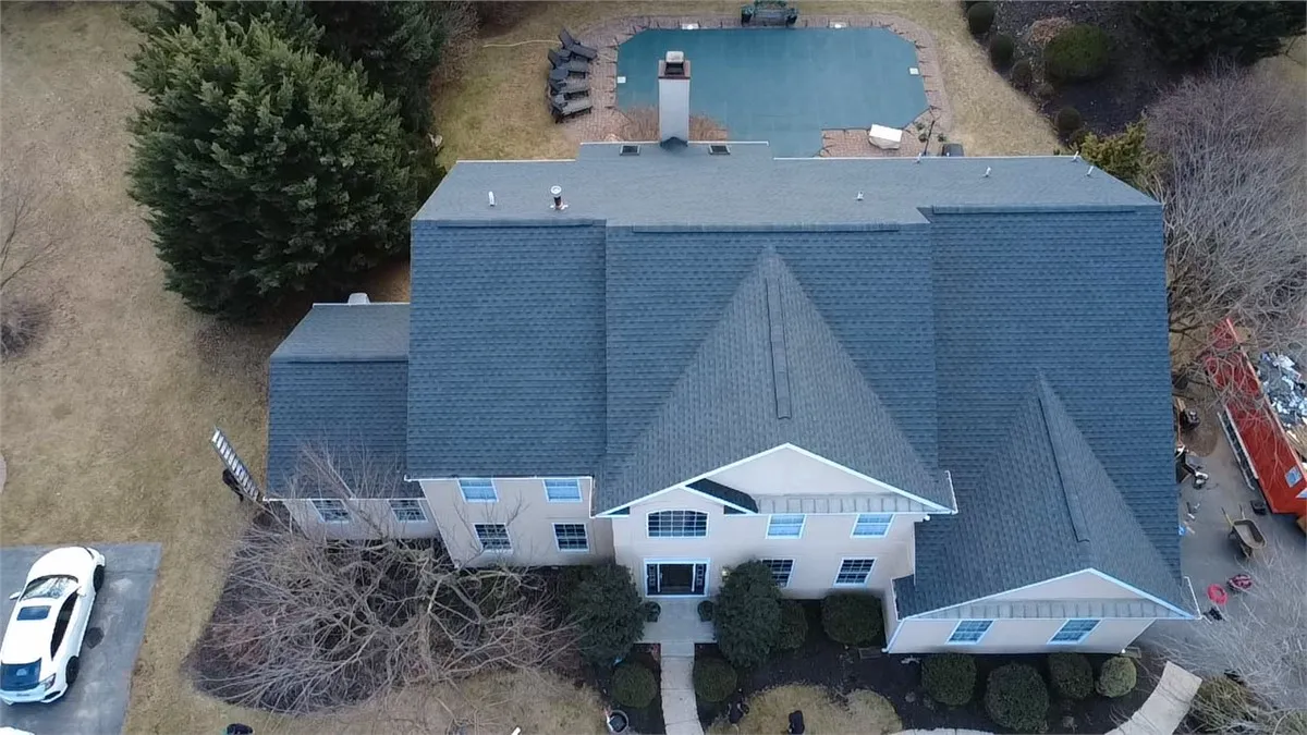 Aerial view of a roof replacement in progress on a two-story home