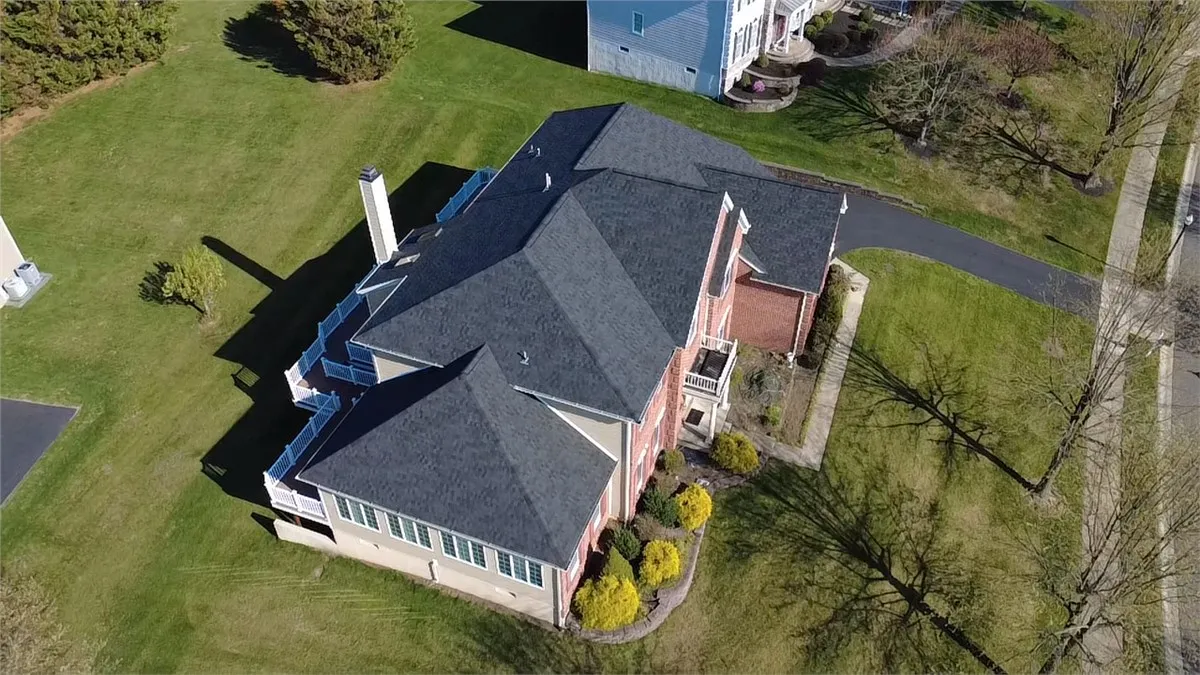 Aerial view of a finished asphalt shingle roof on a two-story home