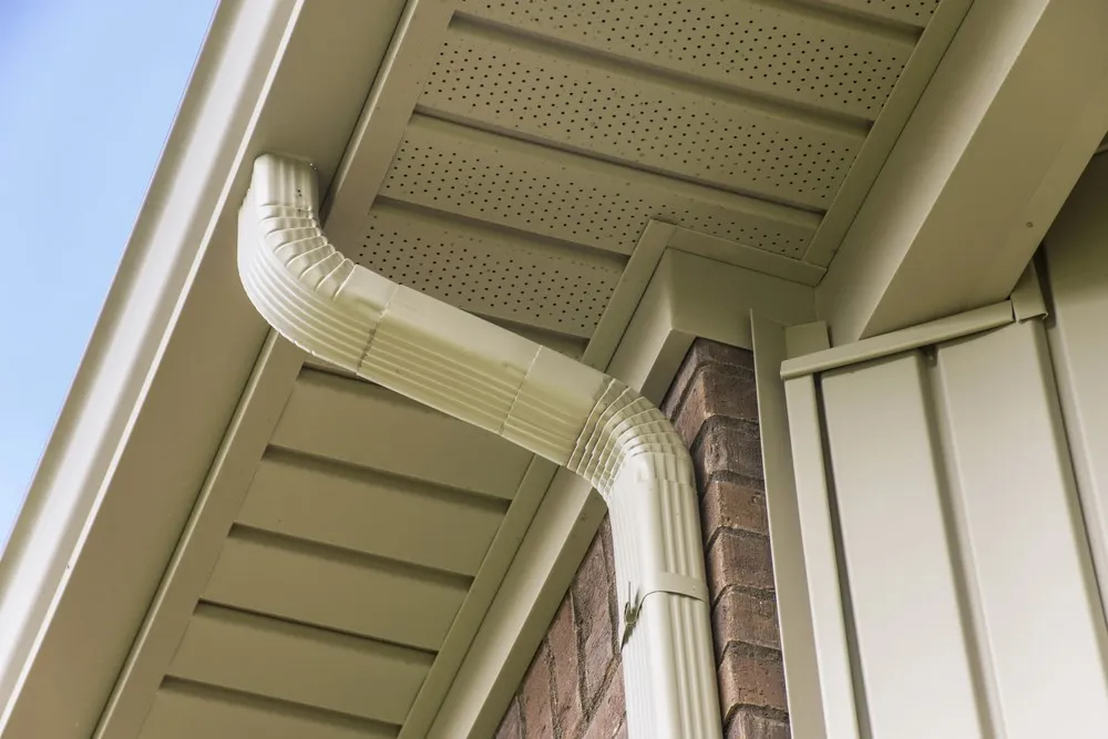 Seamless K-style gutter and downspout along the roof edge of a home
