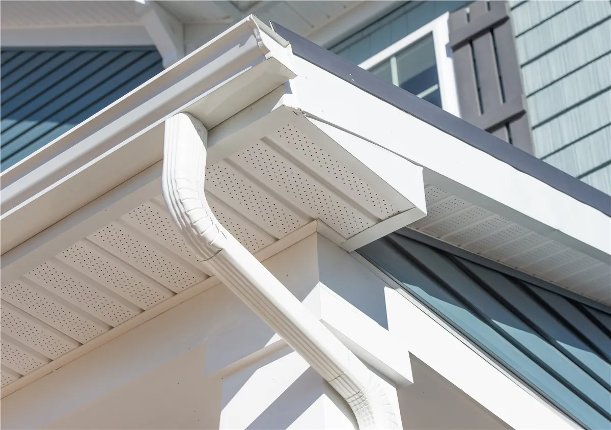 Seamless gutters and a downspout along the roofline of a home